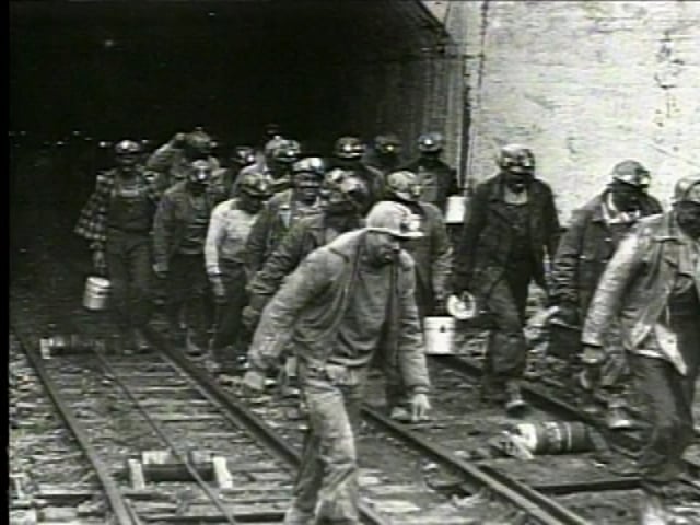 black and white photo of Black steel workers leaving a mine